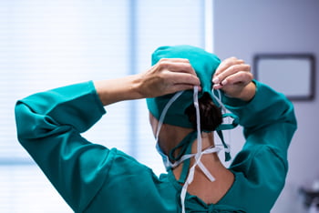 Image of a doctor tying their scrub cap